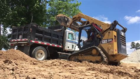 load a dump truck with a mini skid steer|mini on flatbed truck.